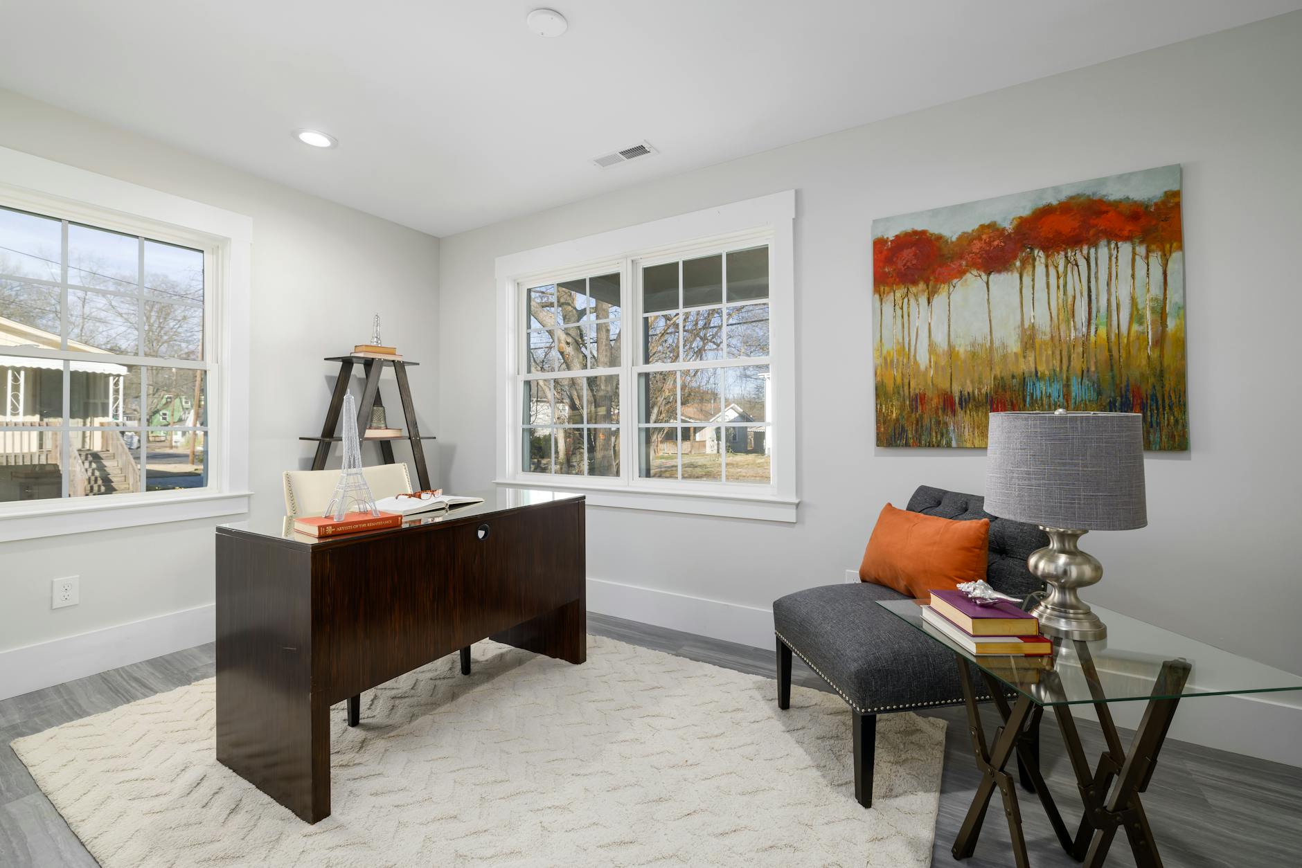 Nowoczesny kącik biurowy w salonie z biurkiem i fotelem przy oknie