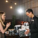 Przyjaciele z radością wymieniają się świątecznymi prezentami w salonie